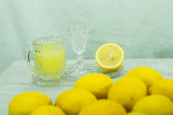 Limoncello. Licor de limón casero tradicional limoncello y cítricos frescos en un plato blanco, enfoque selectivo. - Foto, imagen