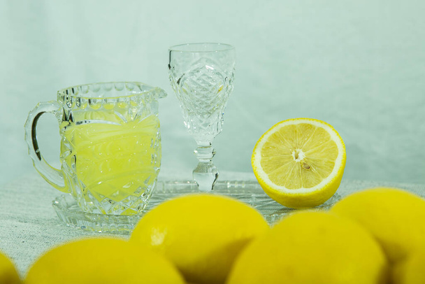 Limoncello. Licor de limón casero tradicional limoncello y cítricos frescos en un plato blanco, enfoque selectivo. - Foto, imagen