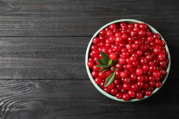 Tasty ripe cranberries on black wooden table, top view. Space for text - Foto, afbeelding