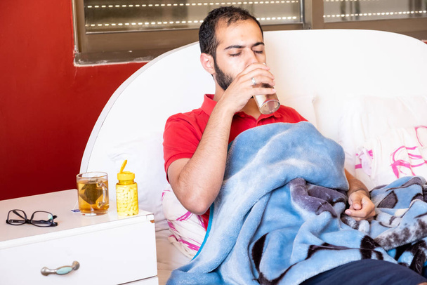 Hombre sintiéndose enfermo, acostado en la cama y tratando de relajarse - Foto, imagen