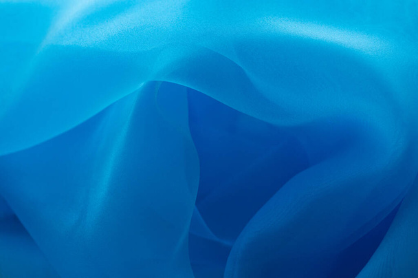 texture bleu clair utilisé comme fond. Texture tissu bleu clair. Tissu organza bleu - Photo, image