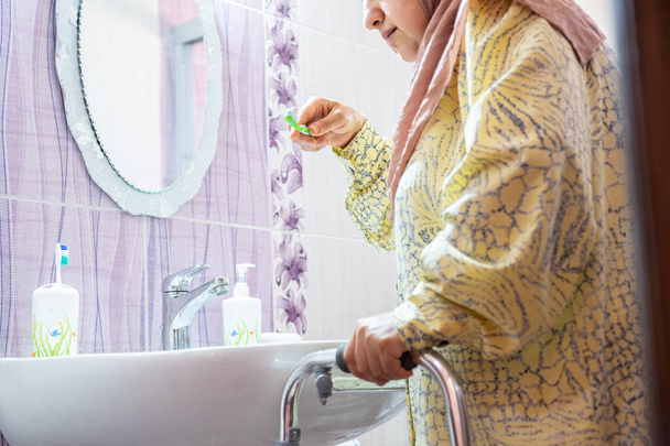 Muslimische Frau mit Behinderung versucht, sich auf sich selbst zu verlassen - Foto, Bild