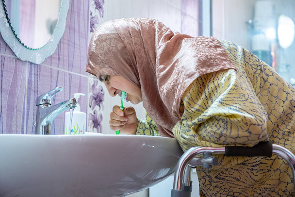 Moslim vrouw met een handicap probeert afhankelijk te zijn van zichzelf - Foto, afbeelding