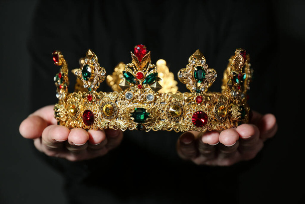 Woman holding beautiful golden crown, closeup. Fantasy item - Photo, Image