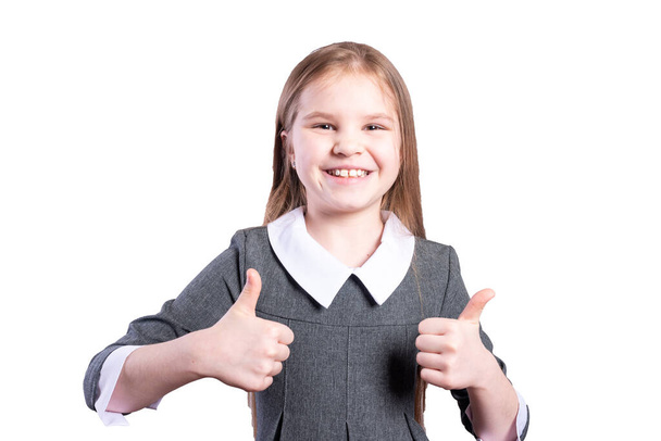 Schoolgirl shows thumbs up. Isolated on white background. High quality photo - Foto, Imagem
