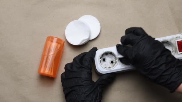 Hände in schwarzen Handschuhen säubern die verschmutzte Plastikverlängerung. Elektrischer Extender reinigen - Filmmaterial, Video