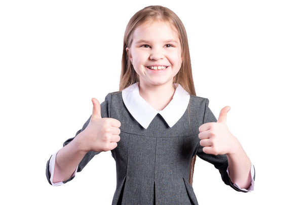 Schoolgirl shows thumbs up. Isolated on white background. High quality photo - Fotografie, Obrázek