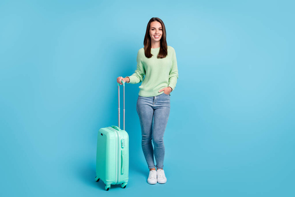 Photo portrait of pretty young female traveler keeping hand on bagagge waiting for train smiling isolated on bright blue color background - Fotó, kép