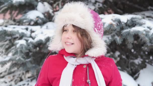 Pieni söpö onnellinen valkoihoinen tyttö talvella hattu pelaa lumipallossa - Materiaali, video