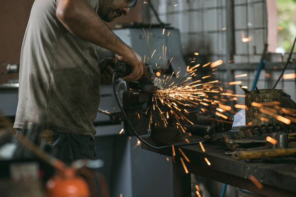 Человек, работающий в механической мастерской с инструментами - Фото, изображение