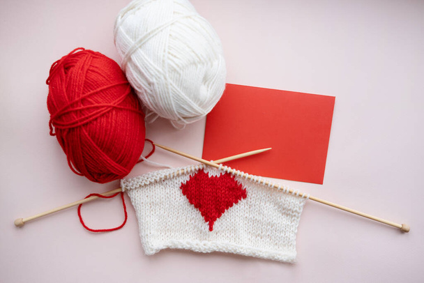 coeur rouge tricoté avec enveloppe rouge, boule de fil. Aiguilles en bois. Valentine. - Photo, image