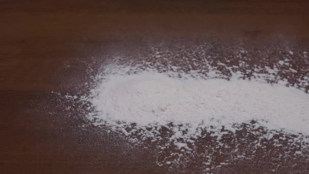 Una pila de harina sobre una mesa oscura. Harina derramada. Textura de harina - Imágenes, Vídeo