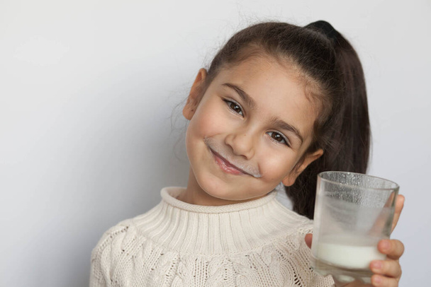 little girl holding a glass of milk - Фото, зображення