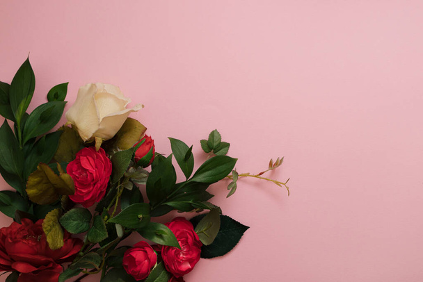 Red and white roses on pink background. Flower bouquet as Valentine's present. Spring mood. - Foto, imagen