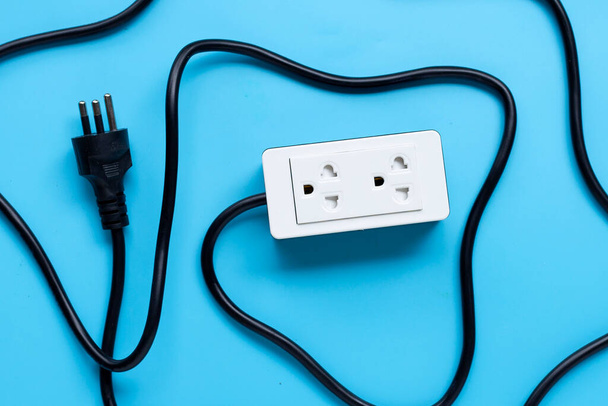 Electrical power strip and plug on blue background. Top view - Foto, Imagen