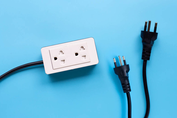 Electrical power strip and plugs on blue background. Top view - Photo, Image