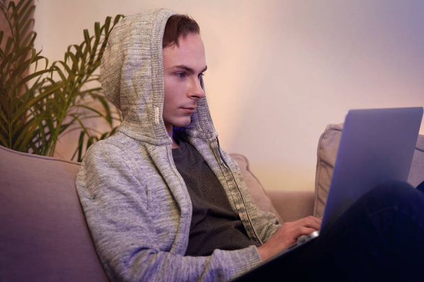 A young male programmer is working at home online during a pandemic. - Foto, afbeelding