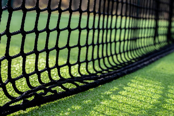 Enfoque selectivo de una red negra para jugar al pádel o al tenis sobre césped artificial verde - Foto, imagen