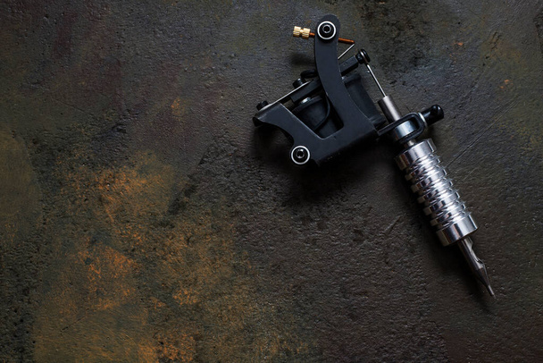 tattoo machine, tattoo gun on rusty metal background - Photo, Image