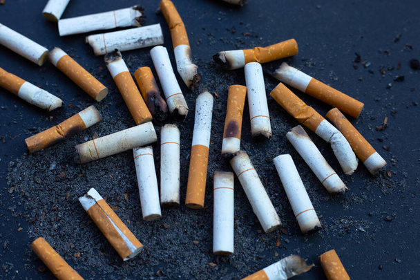Cigarettes buds with ashtray on dark background. - Photo, Image