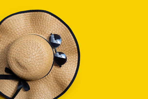Nyári kalap, sárga hátterű napszemüveggel. Élvezze nyaralás koncepció.  - Fotó, kép