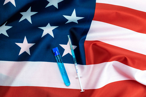 Virüs hücresi ABD. Grip virüsünü ve koronavirüsü korumak için iğneli tıbbi şırınga. Amerikan bayrağı arkaplan aşısı. Hastanede sağlık hizmeti - Fotoğraf, Görsel
