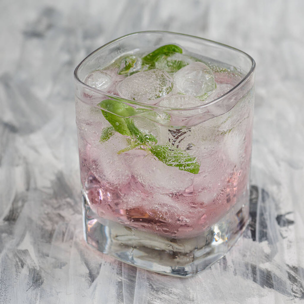 Bebida refrescante com pilhas de gelo e folhas de hortelã em um copo de vidro close-up - Foto, Imagem
