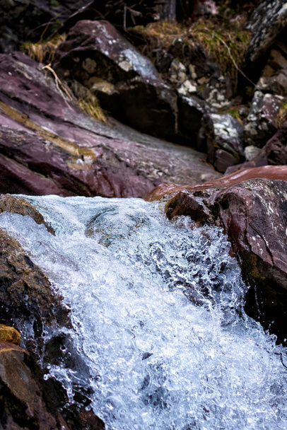detail horského přívalu krystalické vody tekoucí mezi skalami, vertikální - Fotografie, Obrázek