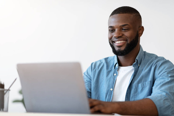 Handsome Black Male Office Employee Working On Laptop Computer, Closeup Shot - Фото, зображення
