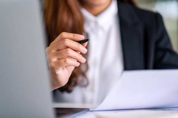 Femme d'affaires utilisant et travaillant sur ordinateur portable et la paperasserie dans le bureau - Photo, image