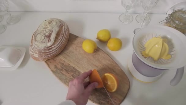 Погані чоловічі руки беруть свіжі апельсини для приготування апельсинового соку, використовуючи спеціальний машинний сніданок вдома вранці
 - Кадри, відео