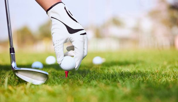 Рука гольфиста кладет мяч для гольфа на поле для гольфа. - Фото, изображение