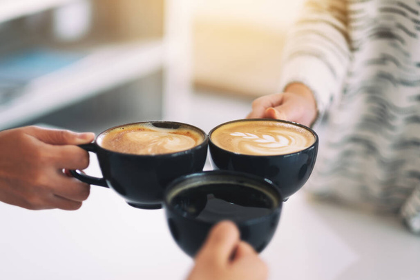 Detailní obrázek lidí těší pití a cinkání šálky kávy na stole v kavárně - Fotografie, Obrázek