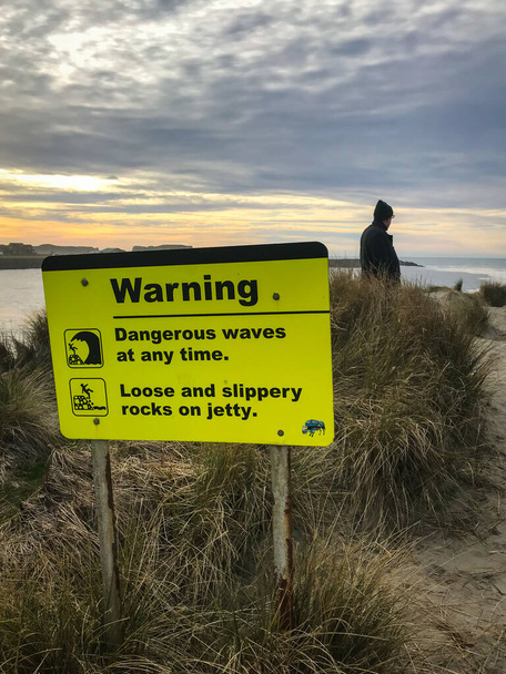 Κίτρινη προειδοποίηση για επικίνδυνα κύματα και ολισθηρούς βράχους. Κάθετη εικόνα.  - Φωτογραφία, εικόνα