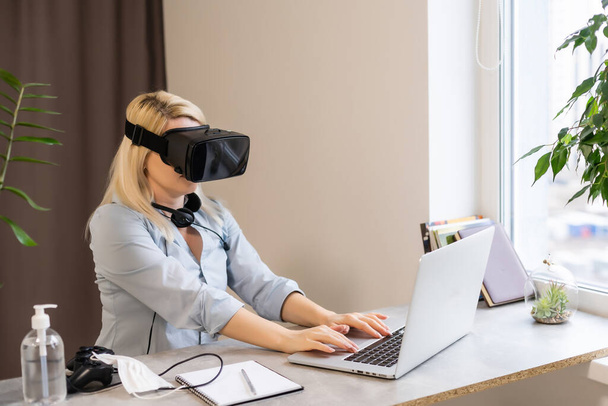 Compuesto digital de mujer jugando con controlador de juego de computadora y auriculares de realidad virtual con fondo borroso brillante - Foto, imagen