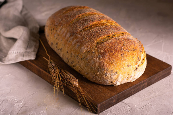 Loaf of whole grain homemade bread and wheat - Fotó, kép