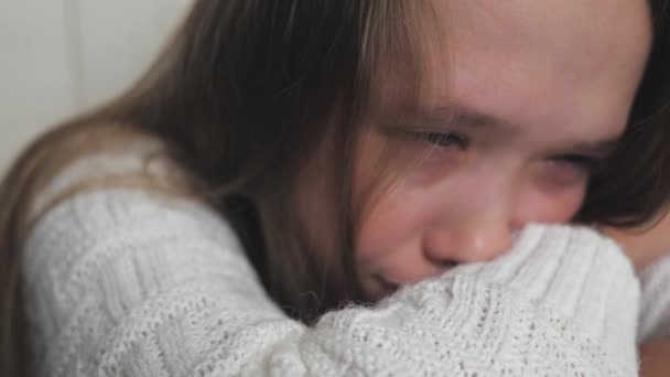 Teini-ikäinen lapsi itkee ja kyyneleet valuvat poskia pitkin. Tyttö on järkyttynyt kehon hormonaalisten muutosten vuoksi. Lasten hermostuneisuus ikäisensä ja vanhempiensa ongelmista. Elämäntyylin sielu itkee. Pelko ja - Materiaali, video