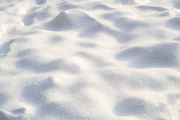 Snow texture on a clear, sunny day. Natural background. Small snow bumps. - Foto, Imagen