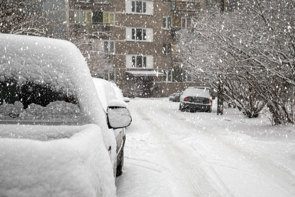 Припаркованные машины, обочина улицы и двор многоквартирных домов. Снег, мороз и погода - Фото, изображение