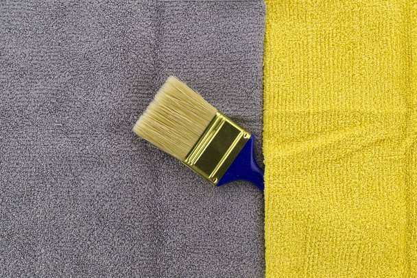 Amarelo colorido e cinza temático natureza morta com pincel limpo em um fundo têxtil cinza e amarelo de dois tons - Foto, Imagem