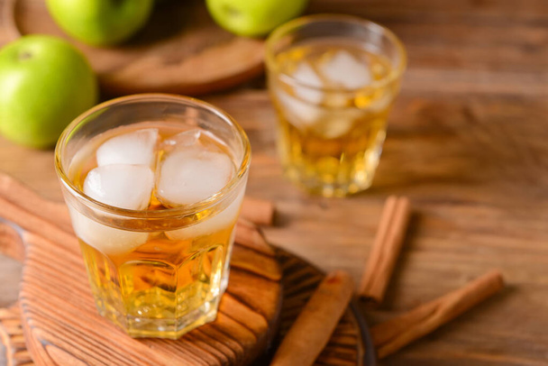 Tasty apple drink with cinnamon in glasses on wooden background - Photo, Image