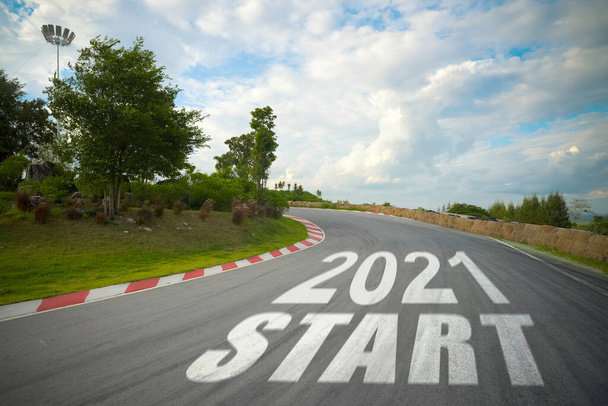 word 2021 start written on road of racetrack straight to mountain. New year 2021 or start straight concept. Concept of planning and challenge or career path, business strategy, opportunity and change - Photo, Image