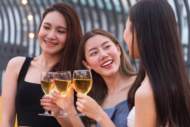 Asyalı genç kadınlar beyaz şarap kadehiyle tezahürat yapıp kadeh kaldırarak yaz partisinde kutlama yapıyorlar. Kutlama, ilişki ve arkadaşlık kavramı. - Fotoğraf, Görsel