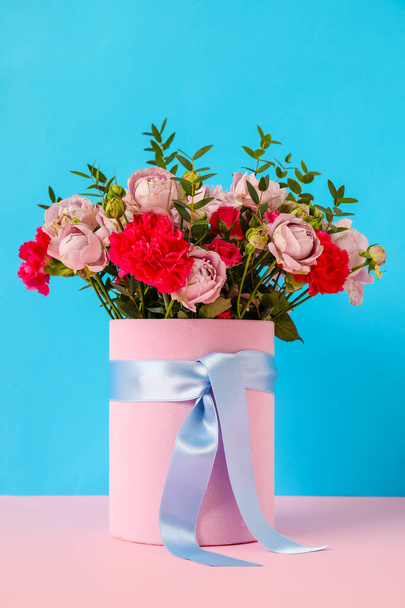Gift box with beautiful flowers on table against color background - Foto, imagen