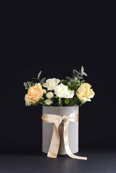 Koyu arkaplanda güzel çiçekler olan hediye kutusu. - Fotoğraf, Görsel