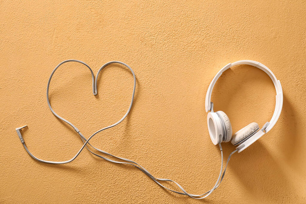 Σύγχρονα ακουστικά και καρδιά από σύρμα σε φόντο χρώμα - Φωτογραφία, εικόνα