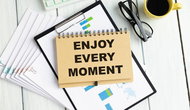 Conceptual handwriting showing Enjoy Every Moment. Business photo text being pleased with your life .Enjoy every moment text written in notepad - Foto, immagini