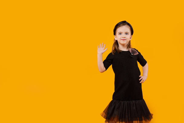 Cute young girl in retro black tulle dress and hair band showing high five gesture - Zdjęcie, obraz