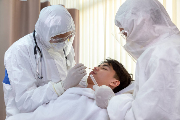 Pielęgniarka i lekarz w garniturze i masce wykonują test Coronavirus COVID-19 PCR. proces pobierania próbek wymazu z nosa i jamy ustnej, procedura diagnostyczna DNA rt-PCR wirusa. - Zdjęcie, obraz