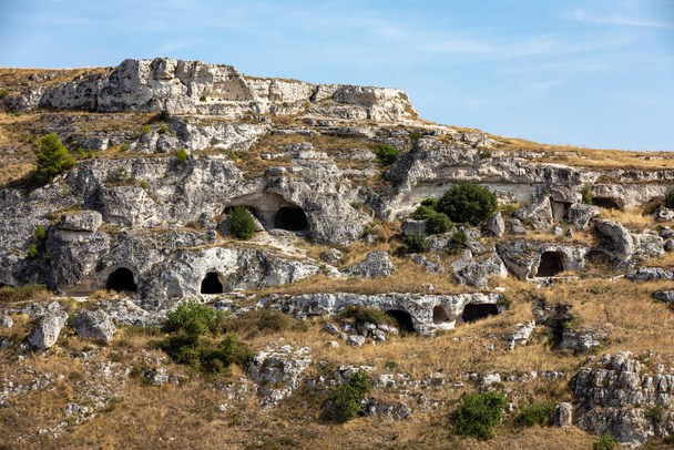 View of Gravina river canyon and park of the Rupestrian Churches of Matera with houses in caves di Murgia Timone near ancient town Matera (Sassi), , Basilicata,  Italy - Фото, изображение